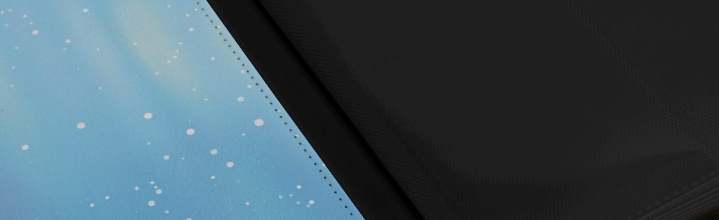 A close-up view of a surface with a gradient blue design featuring small white dots, contrasted with a solid black edge.